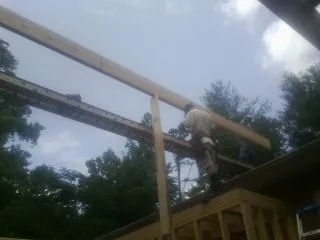 Carpenter setting a ridge beam over a new addition frame — Ice Dam Removal by Roofing Brothers in Orfordville
