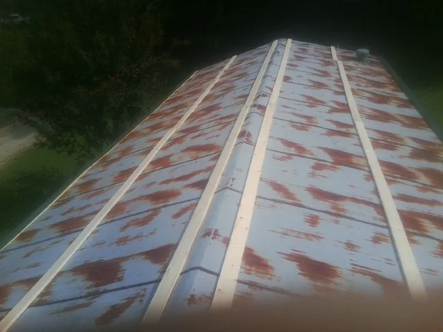 Rusted metal roof panels with new wood purlins before replacement — Storm Damage Roof Repair in Orfordville by Roofing Brothers