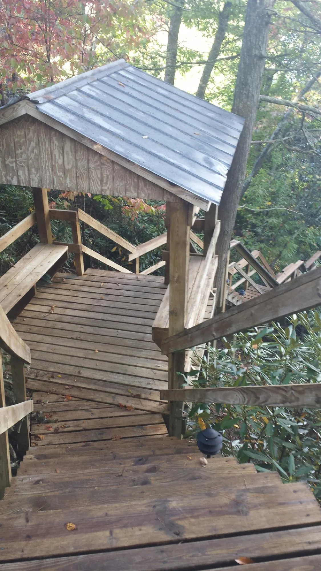 Metal roofed shelter over wooden steps on a wooded walkway — Skylight Repair & Installation work by our crew in Orfordville